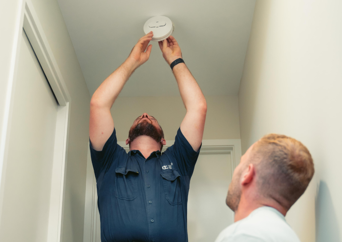 Interconnected photoelectric smoke alarm installed in a hallway