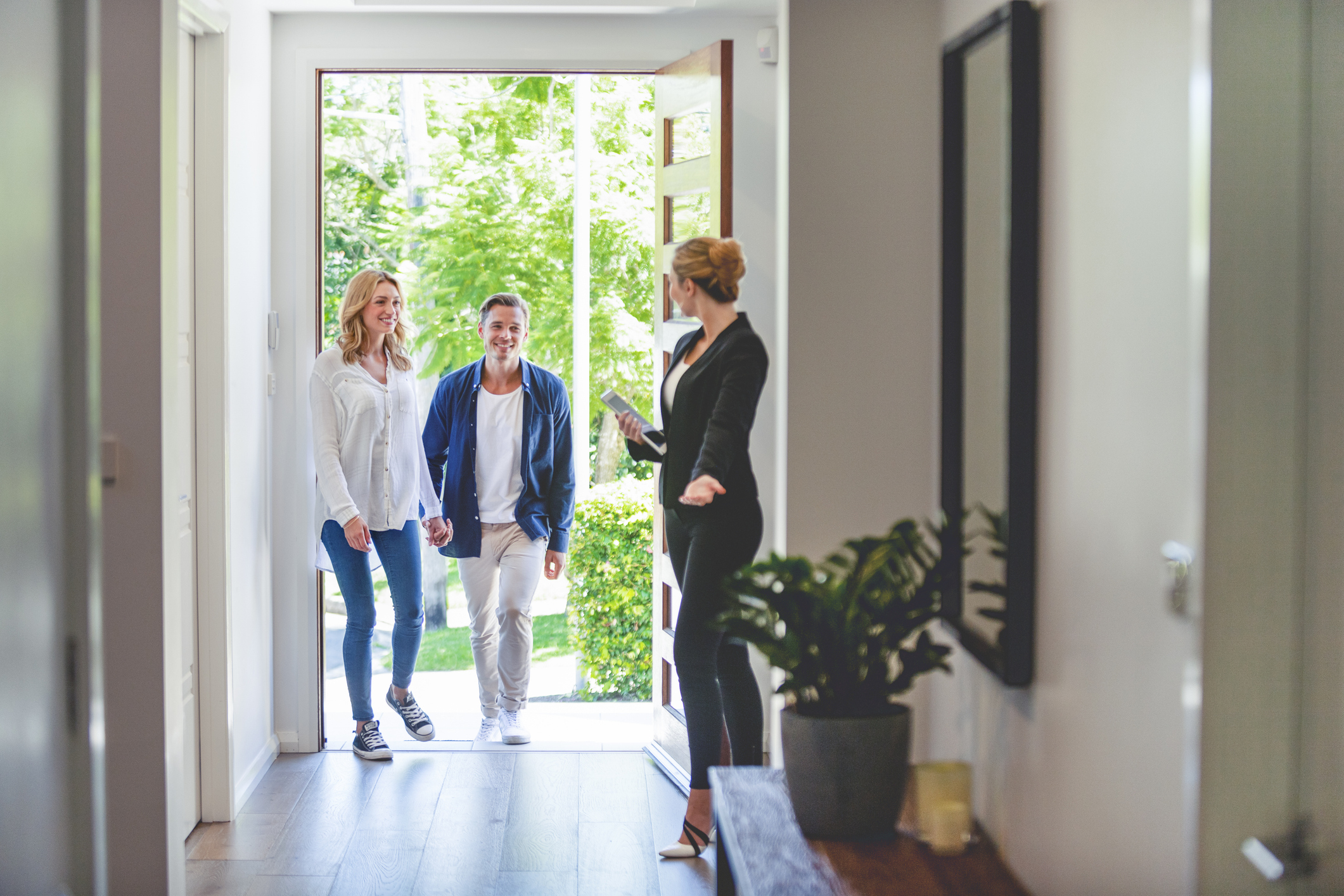 Real estate agent welcoming a couple to a home